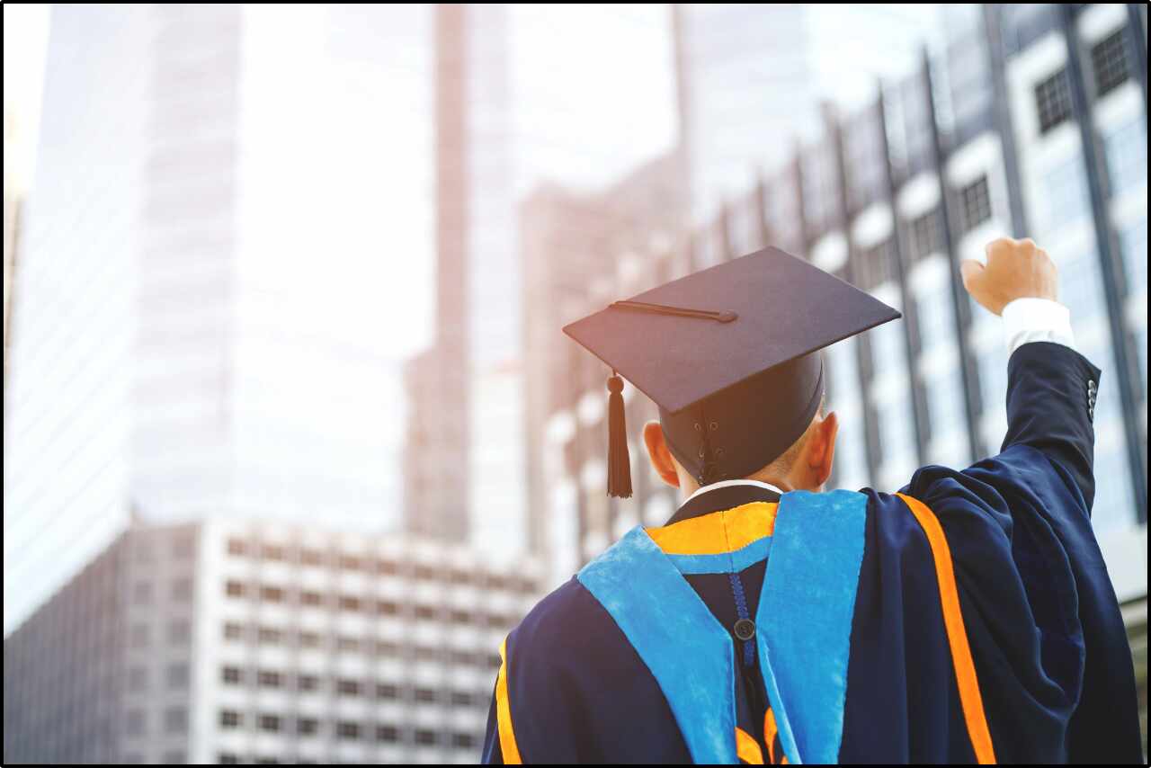 Academic graduate celebrating achievement with raised fist